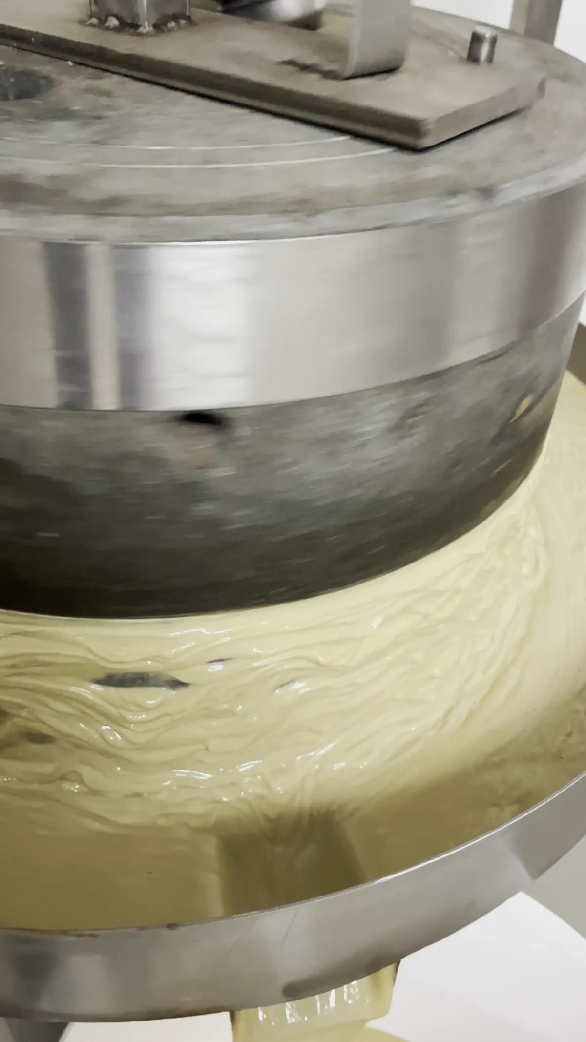 Broyage au moulin en pierre de grès, crème onctueuse qui s'écoule — atelier Noid'Or, Massat Ariège